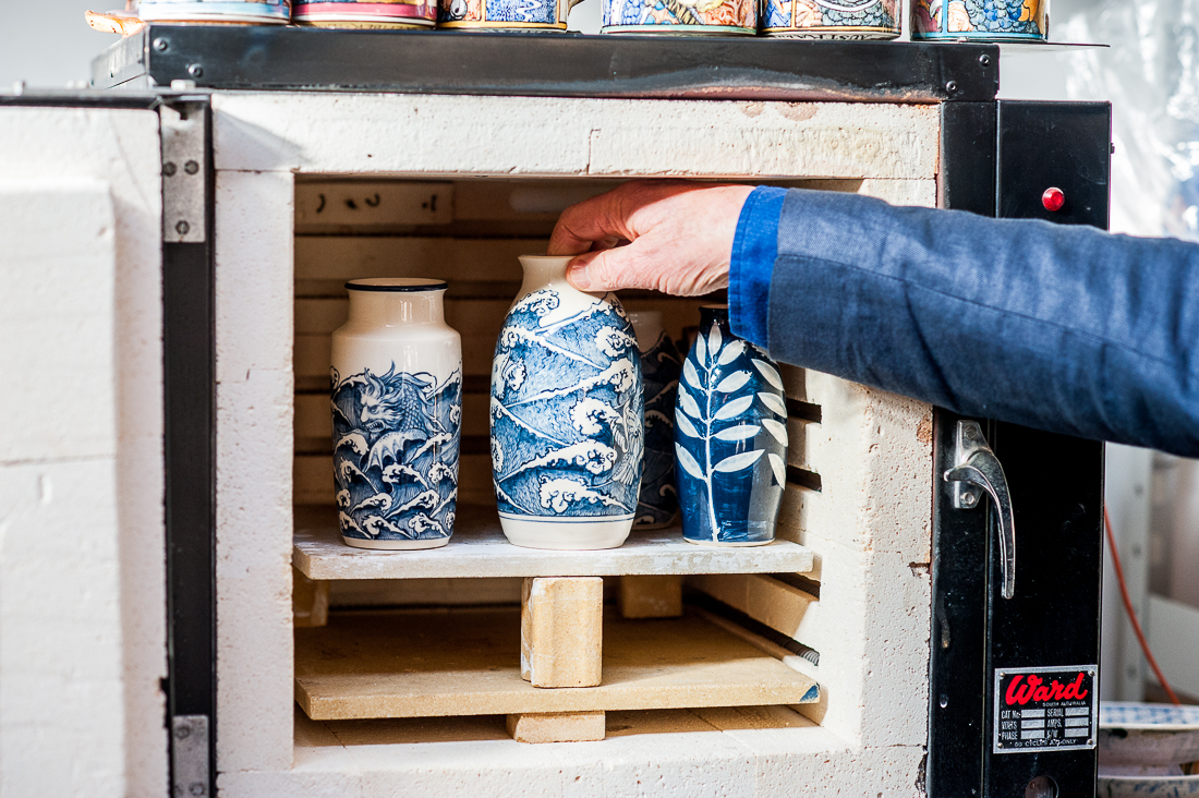 A photograph of the Guildhouse office space, with plants in the left and right side of the image, with a dark artwork in the centre