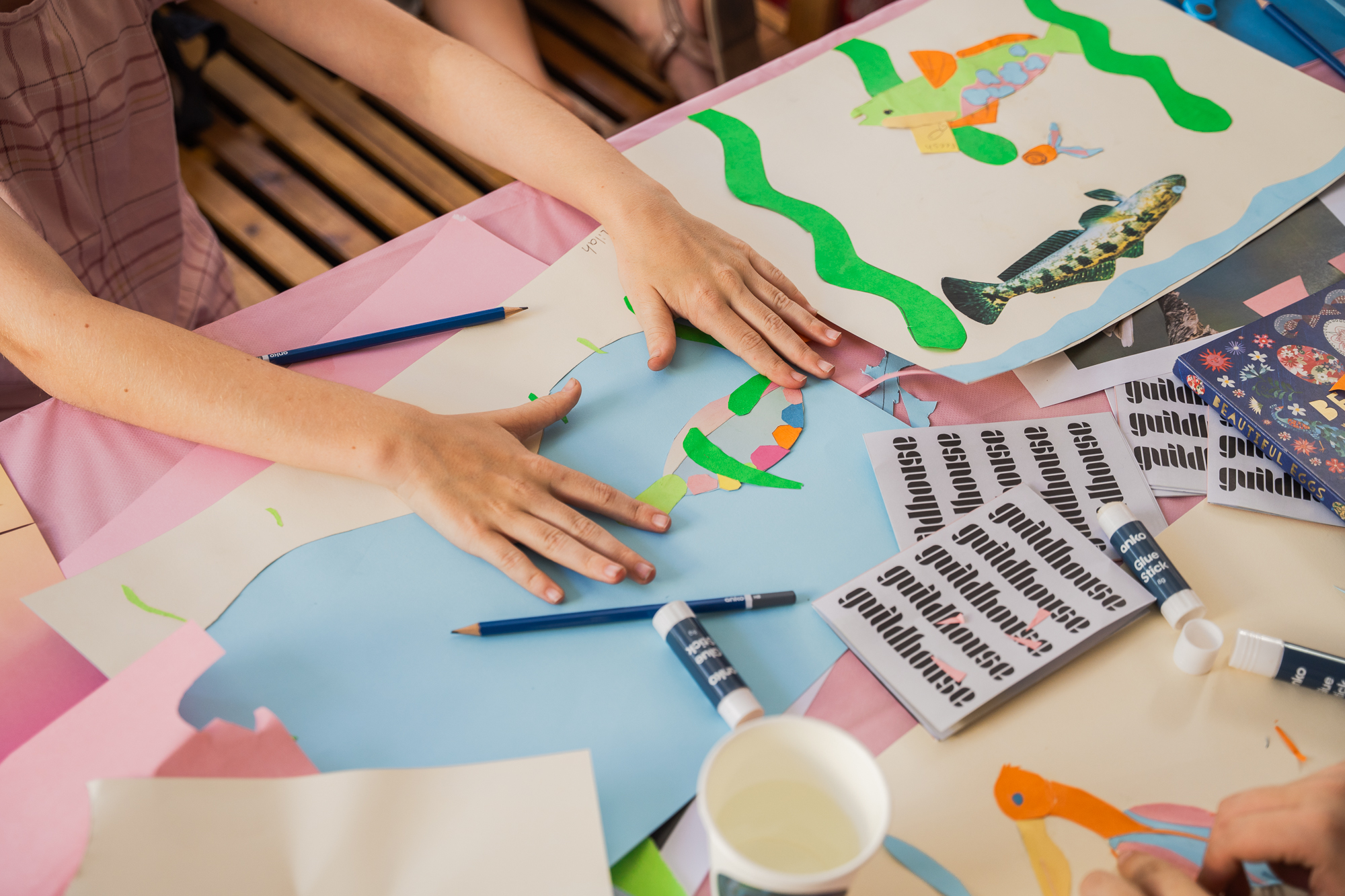 A photograph of the Guildhouse office space, with plants in the left and right side of the image, with a dark artwork in the centre